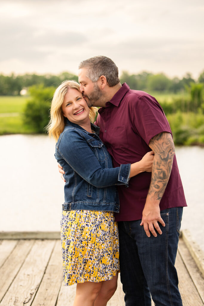 man kissing woman on the temple with woman facing the camera and smiling