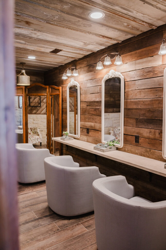 Rustic bridal suite with white lighting and multiple mirrors and bridal stations i
