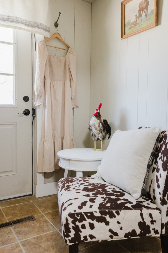 A side room in the house with a cow chair and chicken.
