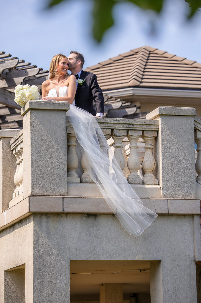 Bride's veil blowing in the wind on stone staircase at the Bourgmont Winery