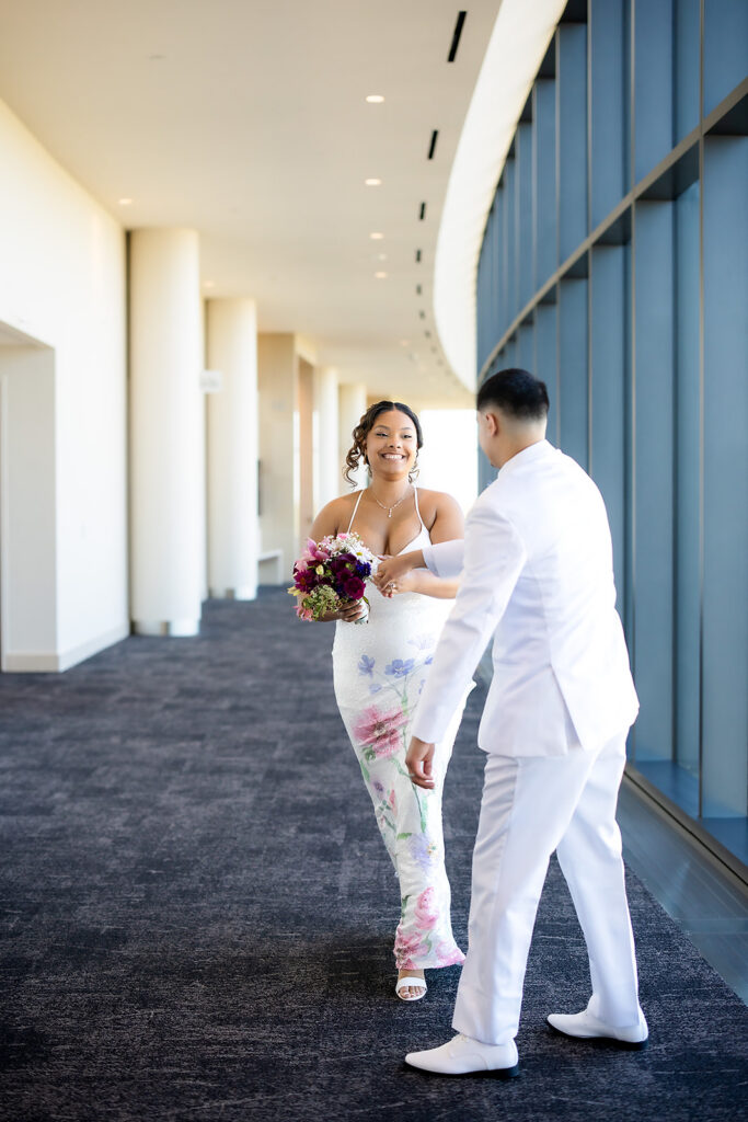 Bride and groom holding hands on grand staircase inside courthouse wedding venue