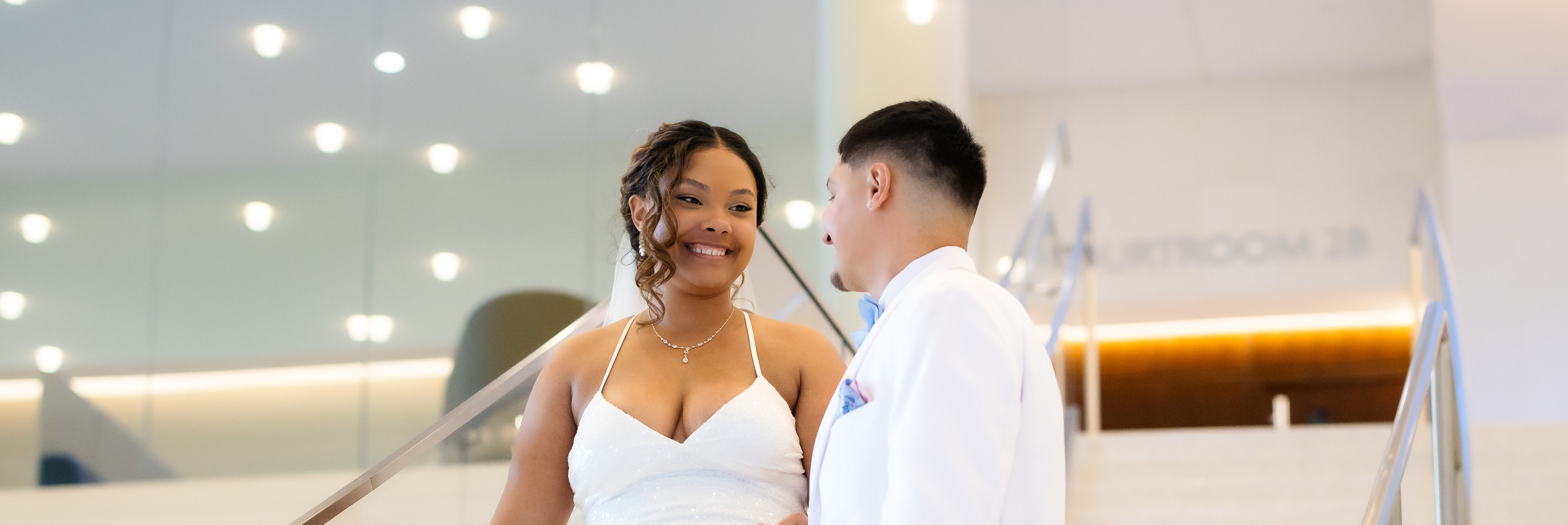 Bride and Groom walking down the white staircase at Johnson County Courthouse